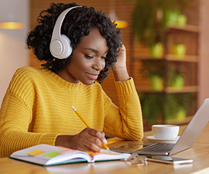Person learning on a laptop with headphones